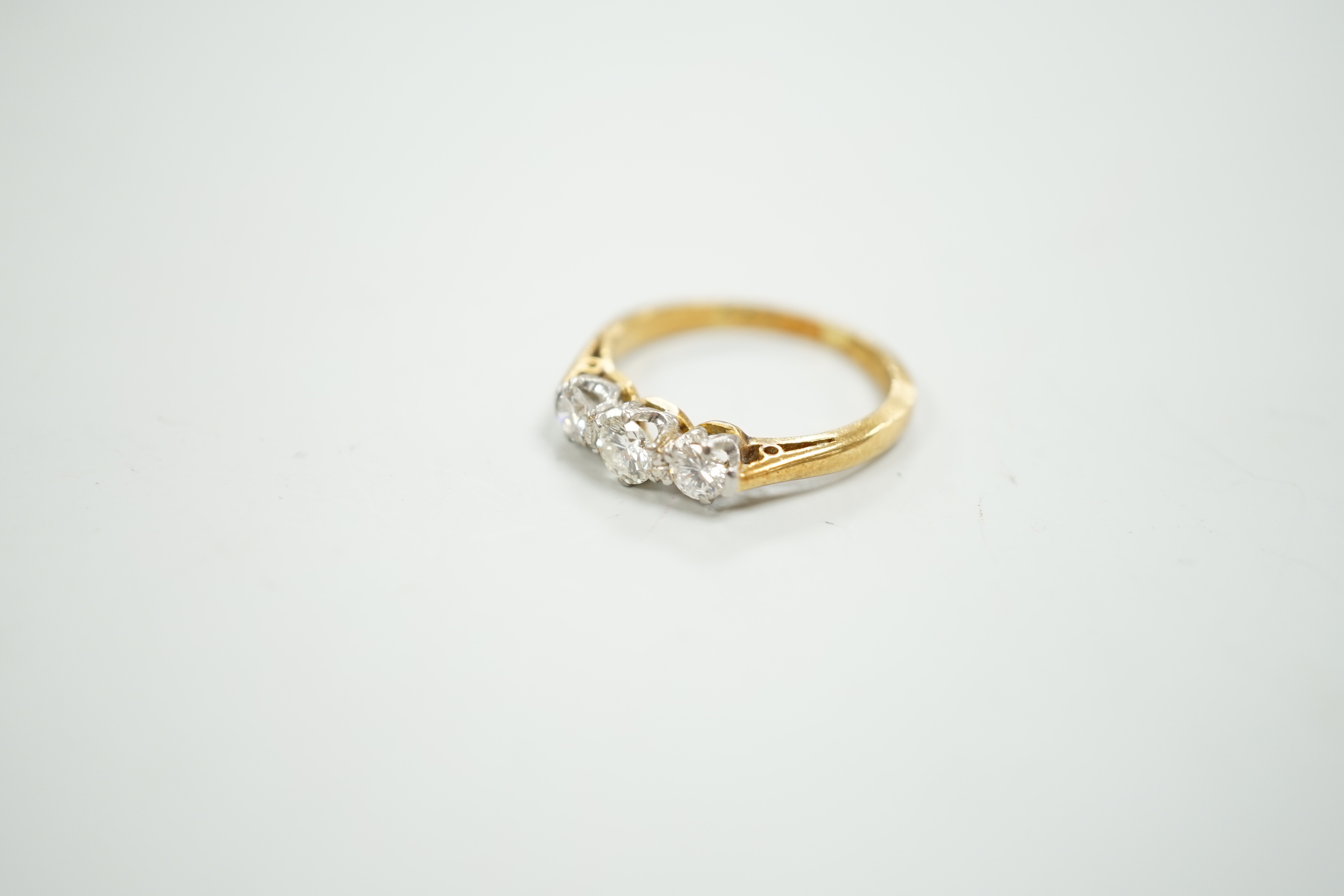 An 18ct, plat and three stone diamond set ring, size K, gross weight 2.7 grams.